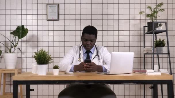 Αφρικανικός Αμερικανός γιατρός εκμετάλλευση έξυπνο τηλέφωνο γραπτών μηνυμάτων. — Αρχείο Βίντεο