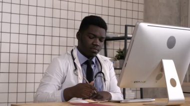 Notlar ve kendi bilgisayarında bir şey arıyor genç Afrikalı-Amerikalı doktor.