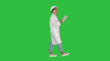 Teftiş ve Chroma Key bir yeşil ekranda dijital tablet gerekli notlar alarak Genç teknisyen.