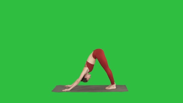 Schöne junge Frau in roter Sportbekleidung, die Yoga oder Pilates macht, steht in Variation von Natarajasana auf einem grünen Bildschirm, Chroma-Taste. — Stockvideo