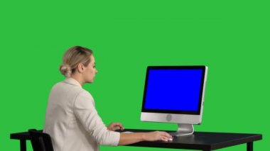 Masada bilgisayar üstünde a yeşil perde, Chroma Key ile iş kişi çalışıyor. Mavi ekran Mock-up.