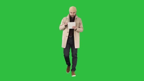 Stylischer Kerl im Internet mit Tablet auf grünem Bildschirm verbunden, Chroma-Schlüssel. — Stockvideo