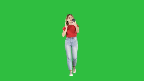 Loira andando e olhando preening no telefone em uma tela verde, Chroma Key . — Vídeo de Stock