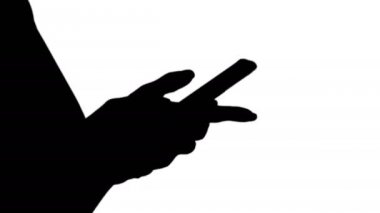 Siluet. Akıllı telefon kullanan güzel bir kadın eli..