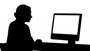 Siluet genç bayan ofiste çalışıyor, masada oturuyor, monitöre bakıyor..