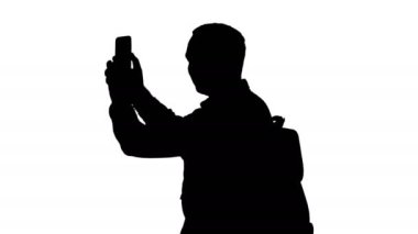 Orta yan görünüm vurdu. Siluet çekici genç turist yürüyüş ve cep telefonuyla sırt çantası ile. 4 k çözünürlüklü profesyonel vurulmuş. 004. sen-ebilmek kullanma o bir örneğin ticari video, işinizde