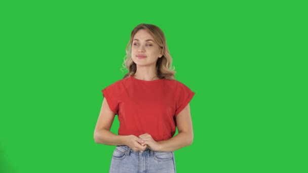 Mujer joven y feliz mostrando un producto apuntando con el dedo a los lados Presentación en una pantalla verde, Chroma Key . — Vídeos de Stock