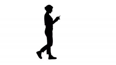 Yürüyüş ve onun cep telefonu kısa mesaj okuma siluet güzel genç kadın.