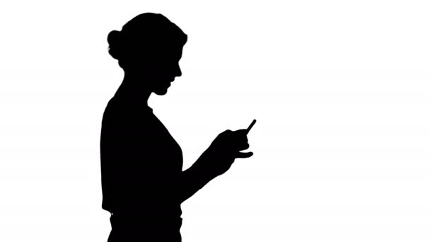 Sylwetka ładna kobieta za pomocą telefonu komórkowego. — Wideo stockowe