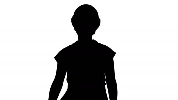 Silhouette Jeune femme en casque jaune marchant. — Video