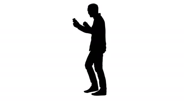 Silhouette Guapo barbudo hombre grabación vlog blog con teléfono inteligente mientras camina . — Vídeo de stock