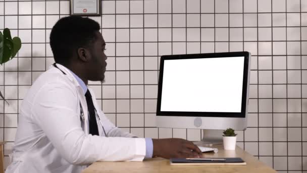 미국 의학 연구소에서는아 프로 미국인 의사가 컴퓨터 화면을 보고 있다. 흰 칠을 하다. — 비디오