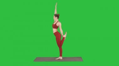İnce kadın yoga poz dandayamana dhanurasana Chroma anahtar yeşil ekranda ayakta.