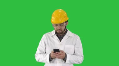 Orta atış. Koruyucu gözlük ve şapka yürüme, bir yeşil ekran, Chroma Key telefonda alarak mühendislik. 4 k çözünürlüklü profesyonel vurulmuş. 004. sen-ebilmek kullanma o bir örneğin içinde ticari video