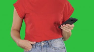 Güzel kadının bir yeşil ekran, Chroma Key tutan, kullanma akıllı telefon eller.