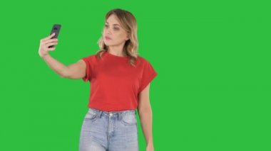 Sevimli kız selfie bir yeşil ekranda Chroma Key yürüyüş yapma.