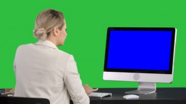 Business woman working on her computer on a Green Screen, Chroma Key. Blue Screen Mock-up Display.