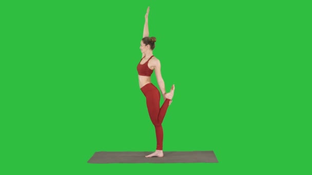 Тонкая женщина, стоящая в позе йоги дандаямана дханурасана на зелёном экране, хрома-ключ . — стоковое видео