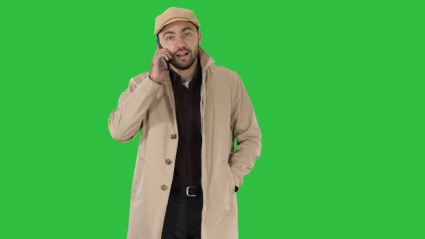 Людина, одягнена в траншею, роблячи телефонуєте під час прогулянки на зелений екран, Chroma Key. — стокове відео