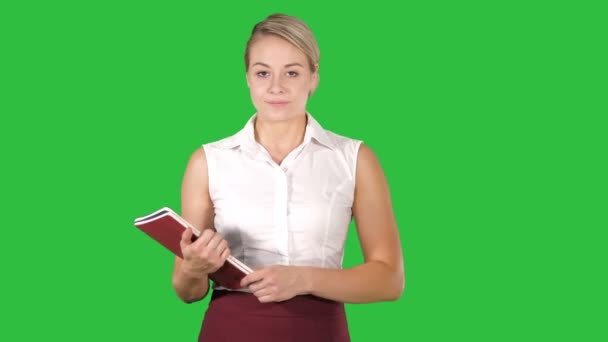 Frau in formeller Kleidung öffnet Notizbücher und blickt auf einen grünen Bildschirm, Chroma-Schlüssel. — Stockvideo