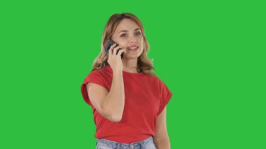 Cep telefonu Chroma anahtar yeşil ekranda kırmızı t-shirt genç güzel kadın konuşuyor.