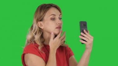 Güzel kadın kendine çeki düzen telefonunu bir ayna gibi bir yeşil ekranda Chroma Key kullanarak.