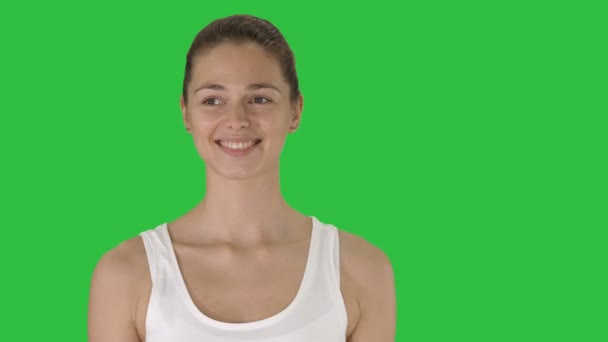 Gelukkig jonge vrouw op zoek naar camera met glimlach tijdens het lopen op een groen scherm, Chromakey. — Stockvideo