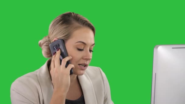 Junge Büroangestellte im Gespräch mit jemandem auf ihrem Handy auf einem grünen Bildschirm, Chroma-Schlüssel. — Stockvideo