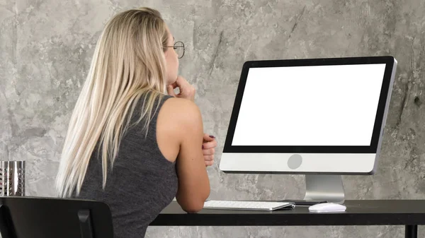 Mujer freelancer mirando el monitor del ordenador. Pantalla blanca . — Foto de Stock