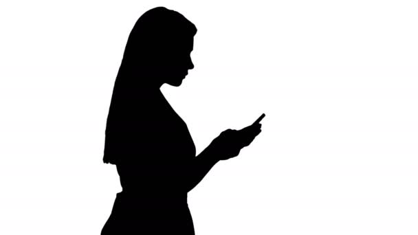 Silhouette hübsche Frau im rosa Kleid SMS auf dem Smartphone. — Stockvideo