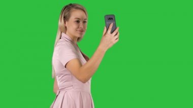 Genç güzel kadın selfie bir yeşil ekran, Chroma Key ona telefon yapar.