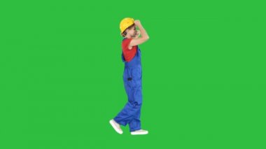 Chroma anahtar yeşil ekranda Sarı kask koyarak inşaat üniformalı genç çekici kadın.