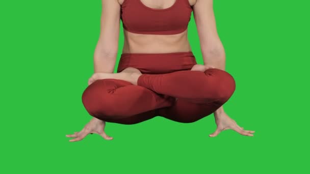 Sportieve aantrekkelijke vrouw beoefenen van yoga, permanent in schaal oefening Tolasana pose op een groen scherm, Chromakey. — Stockvideo