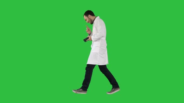 Aantrekkelijke lachen arts lopen op een groen scherm, Chromakey. — Stockvideo