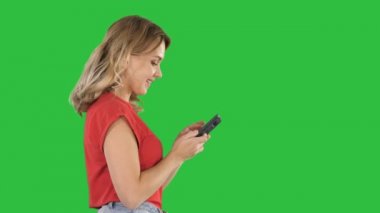 Mutlu sevimli güzel genç kadın oyun oyunlar cep telefonuyla Chroma anahtar yeşil ekran.