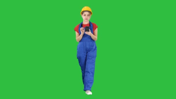 Kvinnlig arbetstagare promenader och använder telefonen på en grön skärm, Chroma Key. — Stockvideo