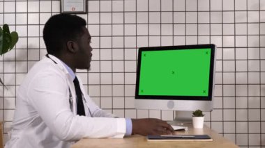 Tıbbi Laboratuvarda Afro-Amerikan doktor bilgisayar ekranına bakıyor. Beyaz Görünüm.