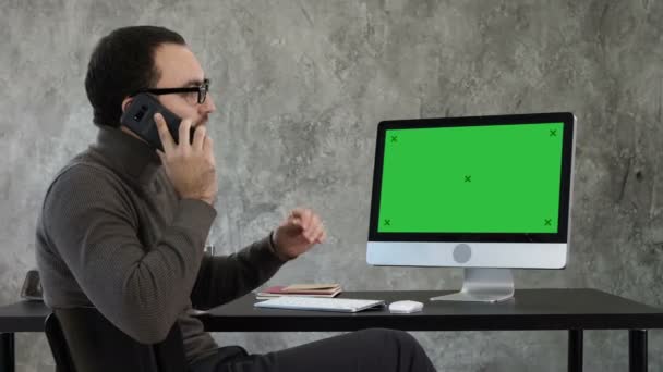Architect talking on the phone discussing the project on the screen of the computer. Green Screen Mock-up Display. — Stock Video