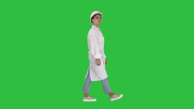 Mühendis inşaat işçisi kadın Chroma anahtar yeşil ekran yürürken komik surat yapıyor.