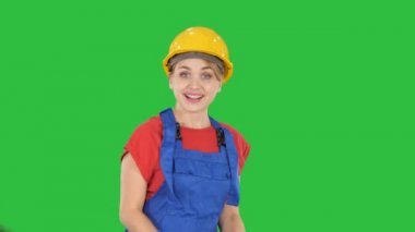 Kadın bir yeşil ekranda Chroma Key dans inşaat kask içinde.