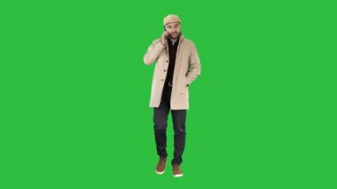 Yürüyüş ve yeşil ekran, Chroma Key telefonda konuşurken trençkot erkekte.