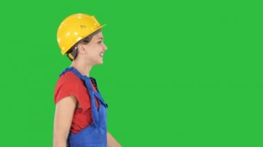 Mutlu İnşaat ve mimari konsept bir yeşil ekranda Chroma Key yürüme hardhat kadın işçi.