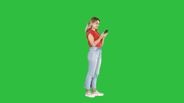 Souriant femme décontractée tenant smartphone en l'utilisant sur un écran vert, Chroma Key . — Video