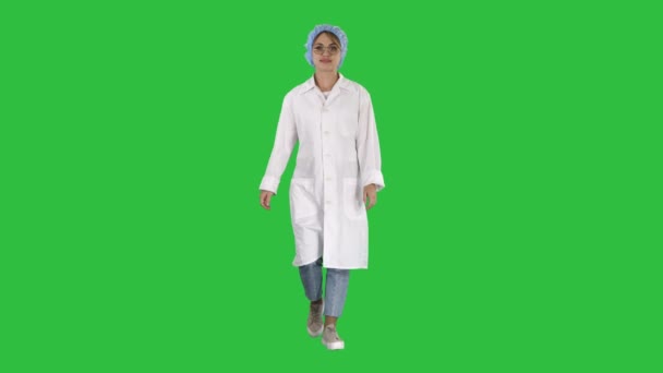 Χαμογελώντας pediatricion κρατώντας τα χέρια στις τσέπες του στολή και το περπάτημα σε μια πράσινη οθόνη, Chroma Key. — Αρχείο Βίντεο