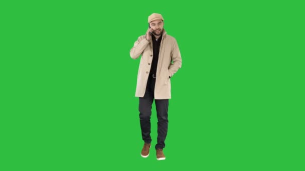 Hombre en gabardina caminando y hablando por teléfono en una pantalla verde, Chroma Key . — Vídeo de stock