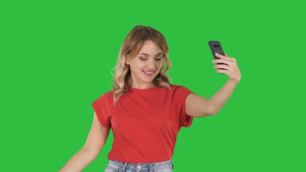 Χαρούμενα θηλυκά blogger εγγραφή βίντεο μπροστινή κάμερα μοντέρνο τηλέφωνο ενώ περπατούν σε μια πράσινη οθόνη, Chroma Key. — Αρχείο Βίντεο