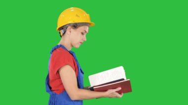 Kadın inşaat işçisi kask ve iş giysisi denetimi listesinde Chroma anahtar yeşil ekranda tek tip.
