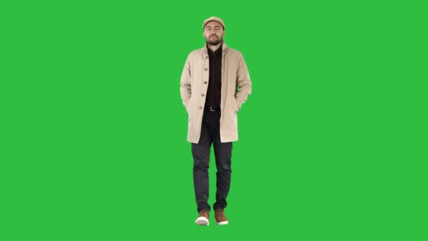 Fiducioso bel giovane uomo che indossa cappotto a piedi su uno schermo verde, Chroma Key . — Video Stock
