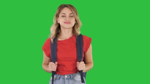 Junge gut aussehende Frau in lässigem T-Shirt mit Rucksack und Jeans, die auf einem grünen Bildschirm läuft, Chroma-Schlüssel. — Stockvideo