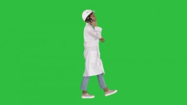 Tam uzunlukta vurdu. Yan görünümü. Kadın bilim adamı bir yeşil ekranda Chroma Key yürüyüş arama yapma. 4 k çözünürlüklü profesyonel vurulmuş. 006. sen-ebilmek kullanma o bir örneğin ticari video, işinizde